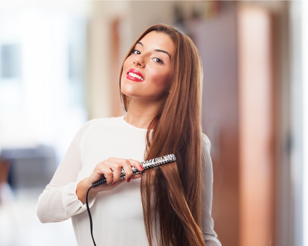 woman using flat hair iron